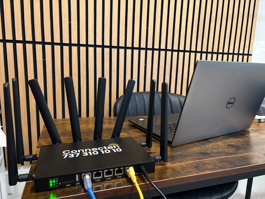 ConnecTen business router on an office desk beside a laptop